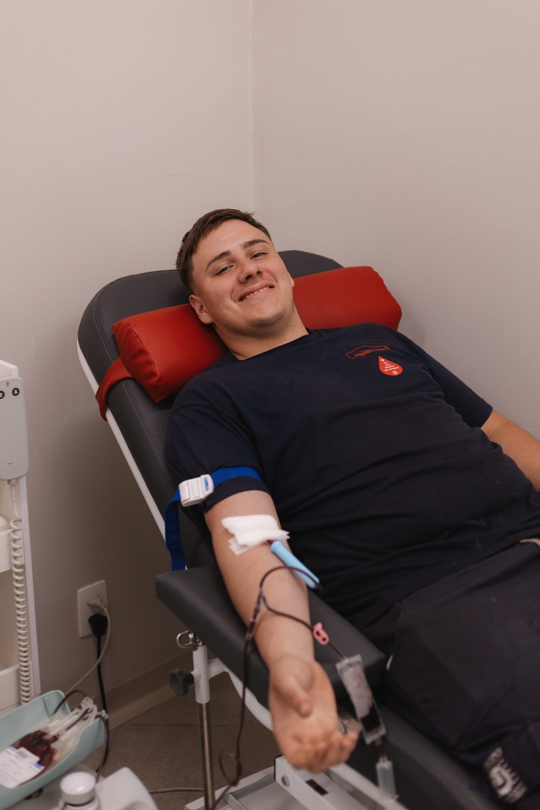 Jovem doador sorrindo na poltrona de coleta